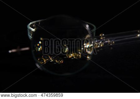Selecetive Focus. View Through Loupe To Soft Translucent Gelatin Capsules Of Golden Color With Essen