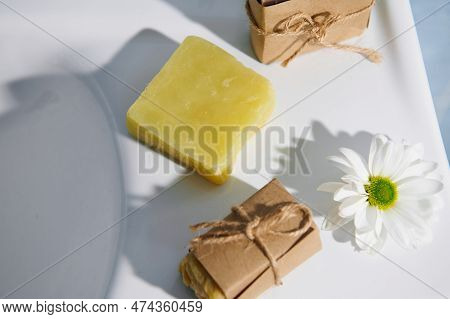 Top View Of Organic Herbal And Floral Cosmetic Soap Bars, Wrapped In Craft Eco Paper And Tied With L