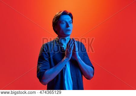 Portrait Of Young Funky Guy, Man Wearing Shirt Standing With Shocked Face, Fear Over Red-orange Back