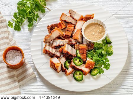 Lechon Kawali, Filipino Crispy Fried Pork Belly With Liver Sauce And Fresh Coriander On White Plate 