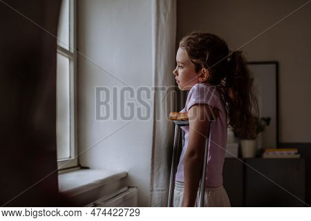 Little Girl With Broken Leg Looking Trough Window.