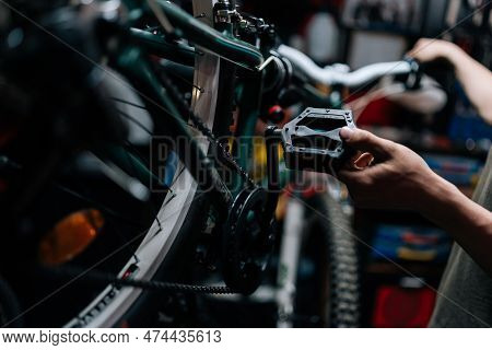 Close-up Cropped Shot Of Unrecognizable Repairman Holding The Pedal Of Bicycle, Insisting Speed Swit