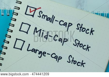 Concept Of Small-cap Stock Write On Book Isolated On Wooden Table.