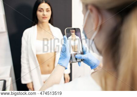 Doctor Cosmetologist Photographs The Body Of Female Patient Before The Procedure In Cosmetology Clin