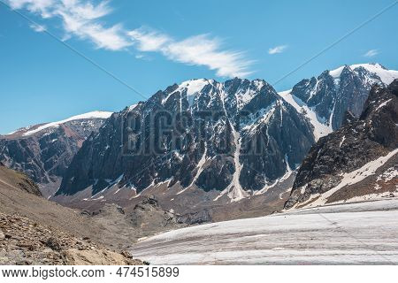 Scenic Mountain Landscape With Glacier Under Sharp Rocks In Sunlight. Awesome Landscape With Glacial
