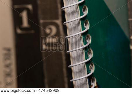 A Spring-loaded Notebook Among Old Brown Book Volumes, Close-up Macro View