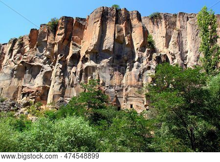 Majestic Rocks With Caves Inside And Green Forest In The Gorge In The Ihlara Valley In Central Anato