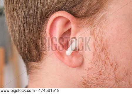 Man Inserts Earplugs So As Not Hear Extraneous Noise, Music, Snoring. Silicone Earplugs For Sleeping