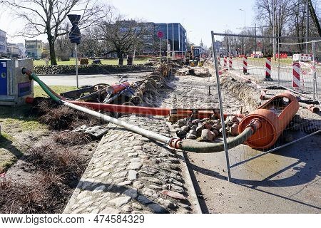 Street Repair Works Site Dewatering System With Water Pump, Pipes And Hoses, Warning Signs And Safet