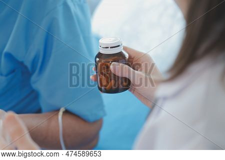 Injured Patient Showing Doctor Broken Wrist And Arm With Bandage In Hospital Office Or Emergency Roo