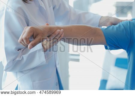 Patient Doing Some Special Exercises Under Supervision In A Room.