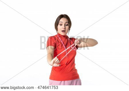 Front View Of A Concentrated Young Girl In Redorange Blouse Streching Elastic Accessory On White Bac