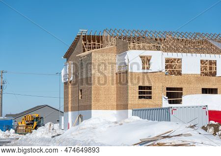 Ground Level View Of A Multifamily Apartment Complex Under Construction In Winter.