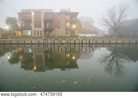 Multistory Modern House Apartment Building Reflection, Fall Leaves In Foggy Morning Mist Along Erie 