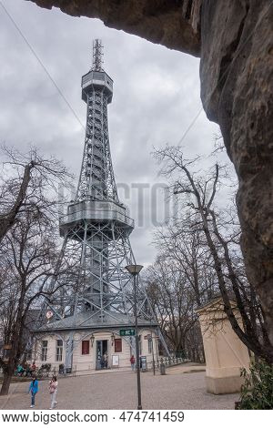 Prague, Czechia - 03.24.2023: Vertical Shot Of Petrin Lookout Tower With People Walking By.