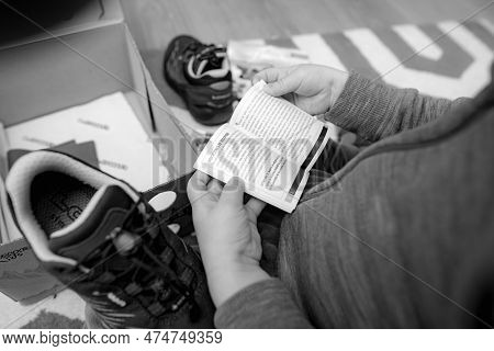 Frankfurt, Germany - Mar 12, 2023: A Young Child Is Seen Indoors, Holding An Instruction Manual Whil
