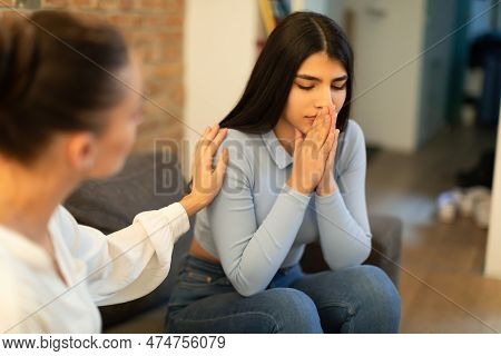 Female Psychologist Calming Sad Spanish Lady, Doctor Consulting Patient In Clinic Office Interior