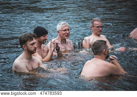 Vilnius, Lithuania - March 26 2023: Group Of Men In Circle Ice Bathing Together In The Cold Water Of