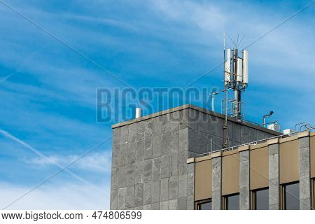 Broadcasting Antenna On The Roof Of The Big Administrative Building. Blue Sky With Light White Cloud