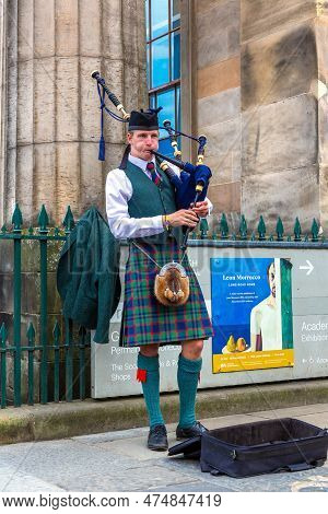 Edinburgh, Uk - June 11, 2022: Bagpiper Playing Music With Bagpipe Near Edinburgh Castle In Edinburg