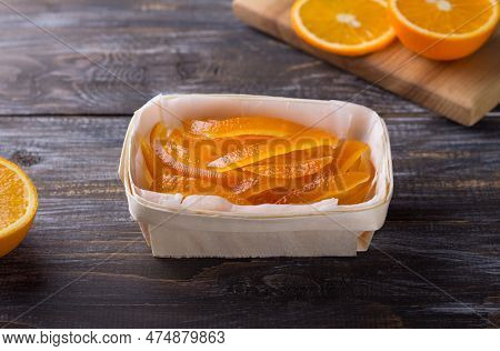 Wicker Birch Basket With Candied Oranges And Fresh Juicy Oranges On Wooden Background
