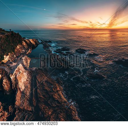 Blue Pool Rock Pool In Bermagui, New South Wales. Aerial Drone Shot During Sunrise With Wam Colors. 