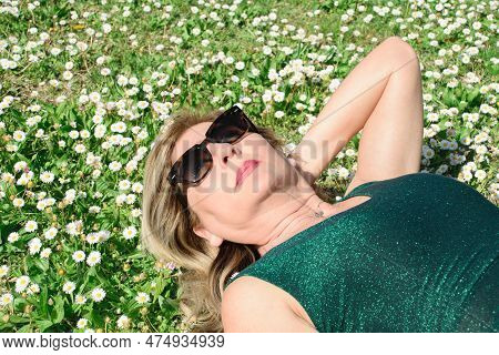 Mother Lied On The Grass And Margherites. Health, Age And Menophause Concept
