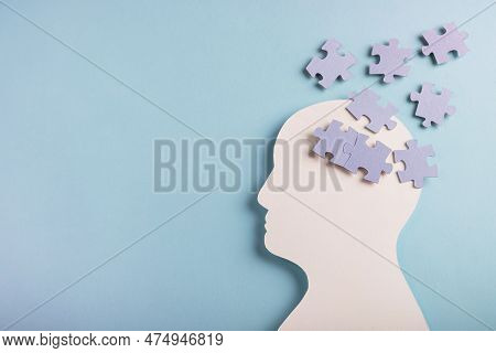Head Silhouette With Puzzles Inside On Pastel Blue Background. Mental Health Concept, Alzheimer Dise