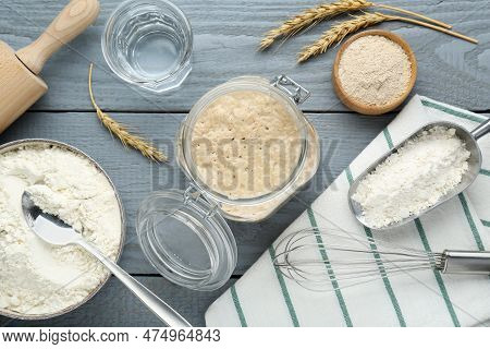 Leaven, Flour, Water, Whisk And Ears Of Wheat On Grey Wooden Table, Flat Lay