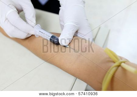 Nurse Taking Blood Sample From Patient At The Doctors Office