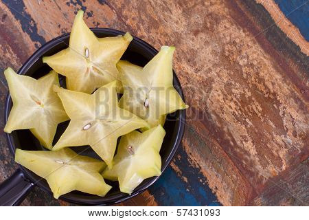 Slices Of Carambola Fruit On Black Plate