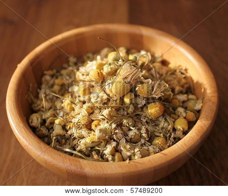 dried chamomiles in the wooden bowl