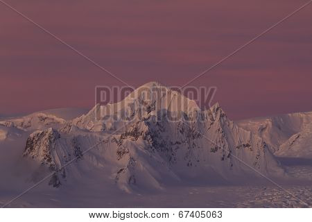 Shackleton Peak In A Chain Of Mountains In The Antarctic Peninsula Against A Red Sky