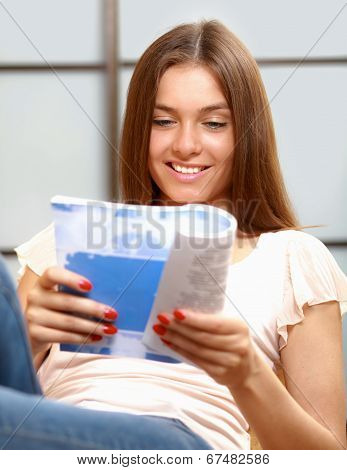 beautiful young woman on the couch with a book