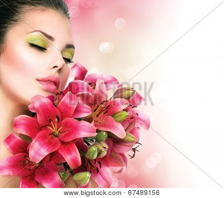 Beauty Girl with Lilly Flowers bouquet. Beautiful Model woman with Blooming pink lily flowers. Nature. Summer. Holiday Creative Makeup. Fashion Make up. Spa woman Portrait