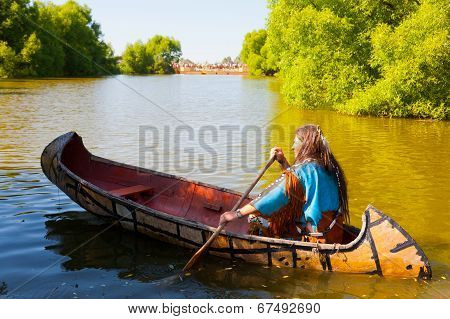 North American Indian floats down the river on a canoe
