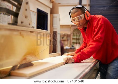 Apprentice Using Circular Saw In Carpentry Workshop