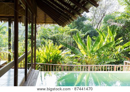 leisure, travel and tourism concept - swimming pool and bungalow at hotel resort