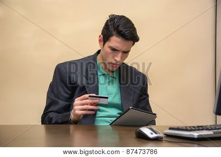 Sitting Businessman Holding Credit Card and Tablet