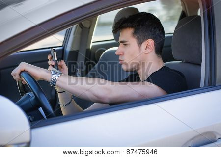 Handsome Young Man Using his Cell Phone Driving a Car