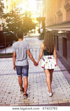 Young couple walking through the city holding hands
