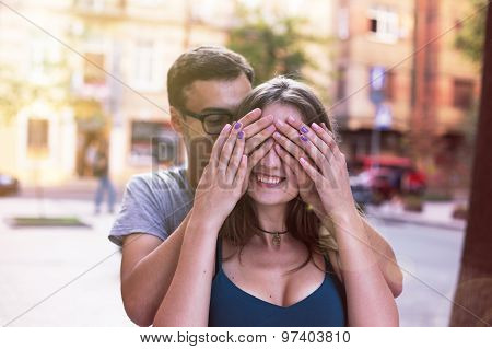 Man closes his eyes for the girl making her surprise smiling