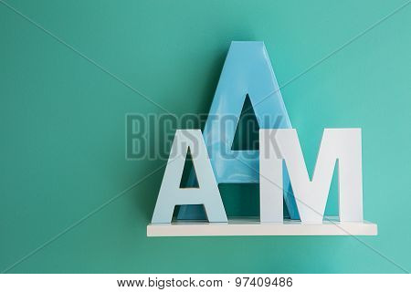 Letters A and M on a white shelf.