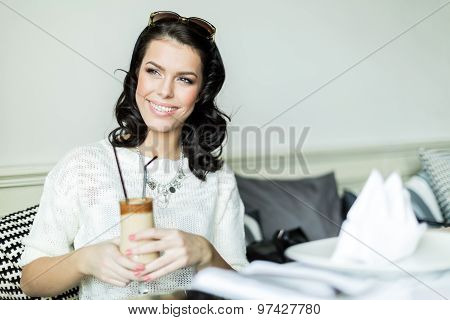 Gorgeous  Lady Smiling In A Restaurant While Holding Her Coffee