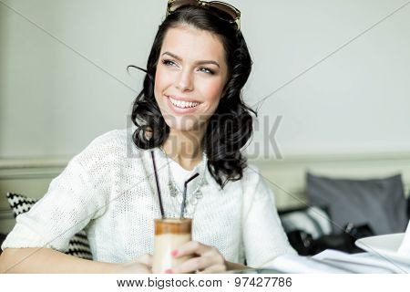 Gorgeous Lady Smiling In A Restaurant While Holding Her Coffee