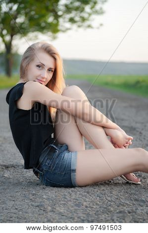 Beautiful Girl Sitting On The Road