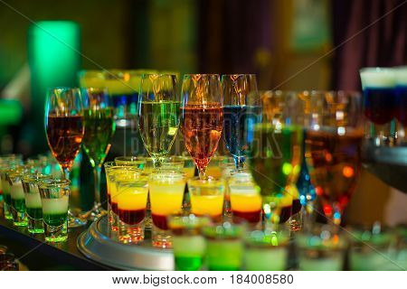 cocktail colorful background in night club on table top in bar mix alcoholic drink in glass at restaurant party