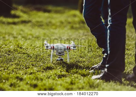 Ukraine Poltavskaya region Kremenchuk - April 26 2017: Man controls a quadrocopter. Launching a quadrocopter DJI Phantom 3 Standard in the park. Preparation quadrocopter to fly.