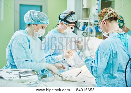 surgeons at work. female nurse operating in child surgery hospital