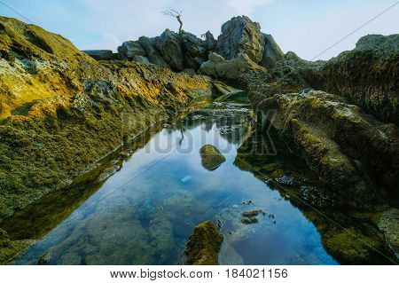 Long exposure of sea & rocks during beautiful evening at Labuan island,Malaysia.Known as Bonsai lonely tree Layang Layangan & lconic landmark in Labuan island,Malaysia.